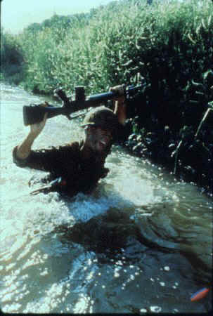 stephen caffrey holding M16 above head in water 